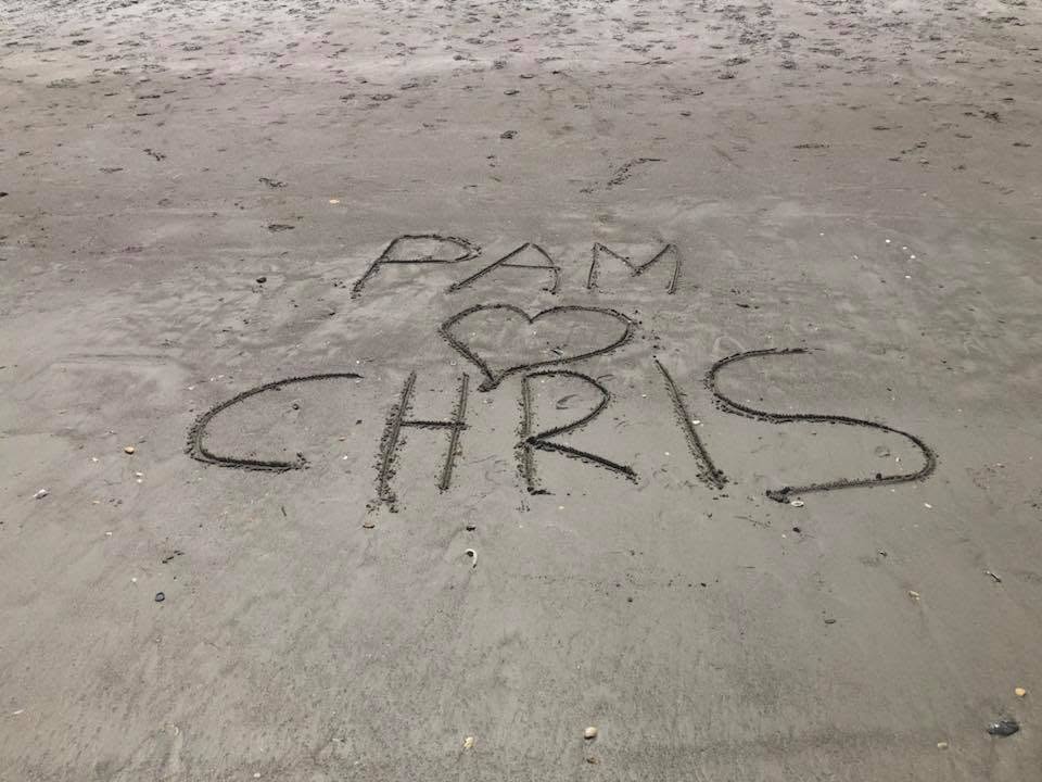 Pam and Chris written in the sand